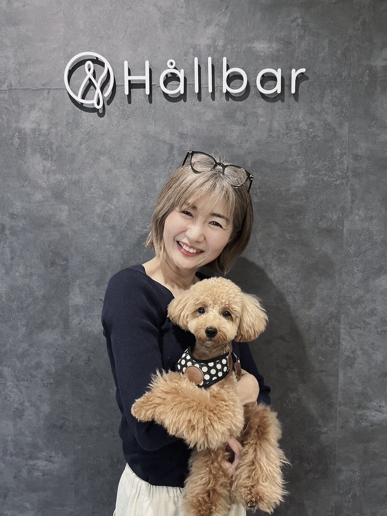 犬を抱いて笑顔で立つ石井淳子