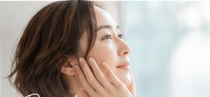 自分の肌を見つめる女性のイメージ